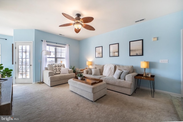 carpeted living area with baseboards, visible vents, and a ceiling fan