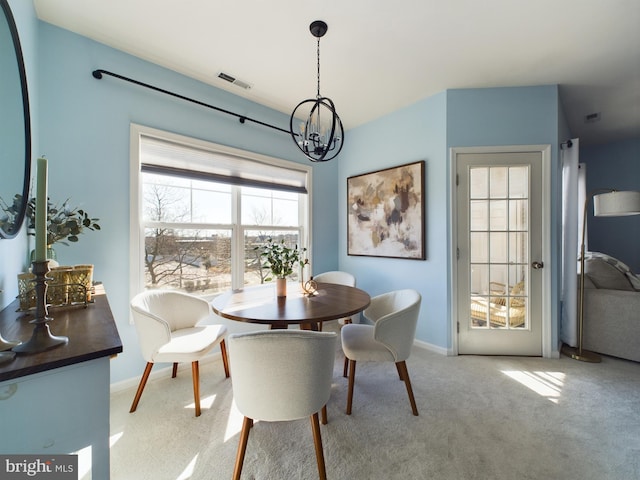 dining room featuring light carpet, visible vents, baseboards, and an inviting chandelier