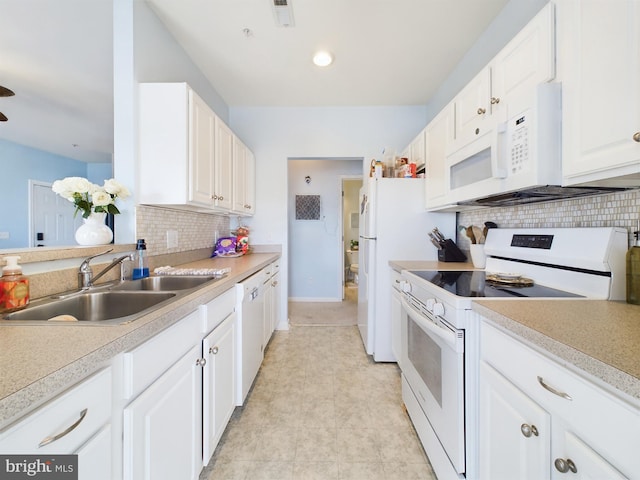 kitchen featuring white appliances, visible vents, light countertops, white cabinetry, and a sink