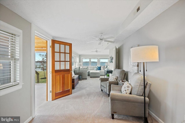 sitting room with carpet, visible vents, and baseboards