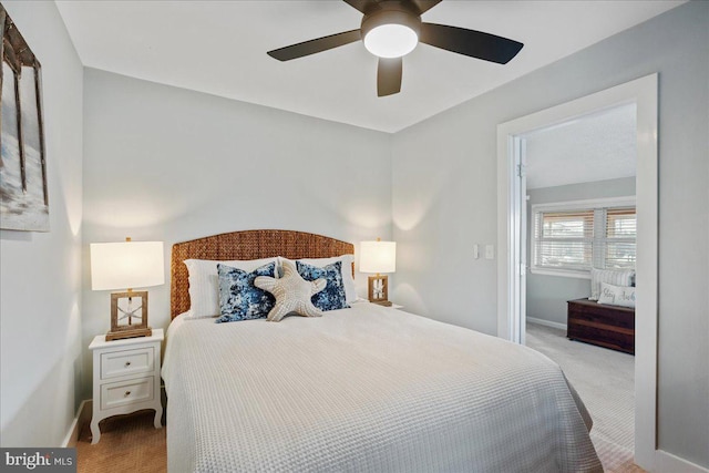 carpeted bedroom with ceiling fan and baseboards