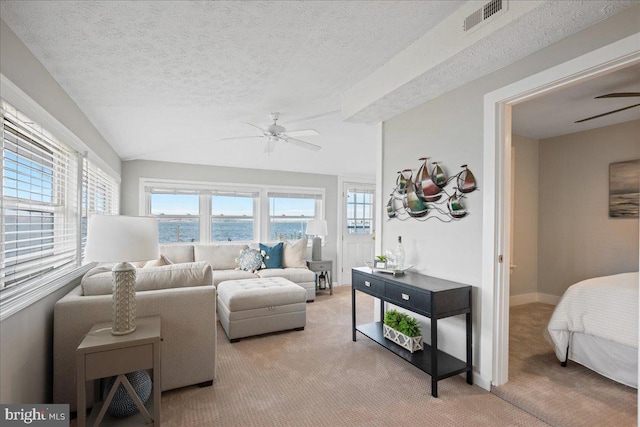 living room featuring visible vents, a ceiling fan, light colored carpet, lofted ceiling, and a textured ceiling