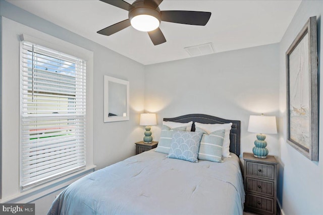 bedroom with ceiling fan, multiple windows, and visible vents