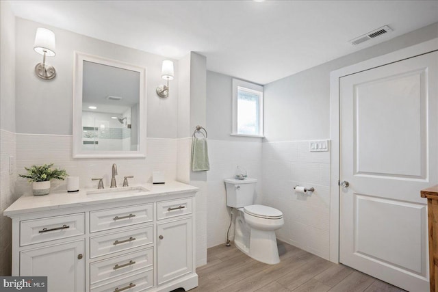 bathroom featuring visible vents, vanity, toilet, and wood finished floors