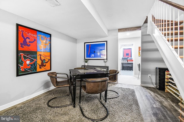 dining room with visible vents, stairway, baseboards, and wood finished floors