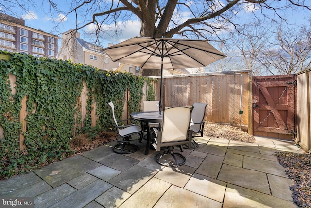 view of patio / terrace featuring a fenced backyard, a gate, and outdoor dining space