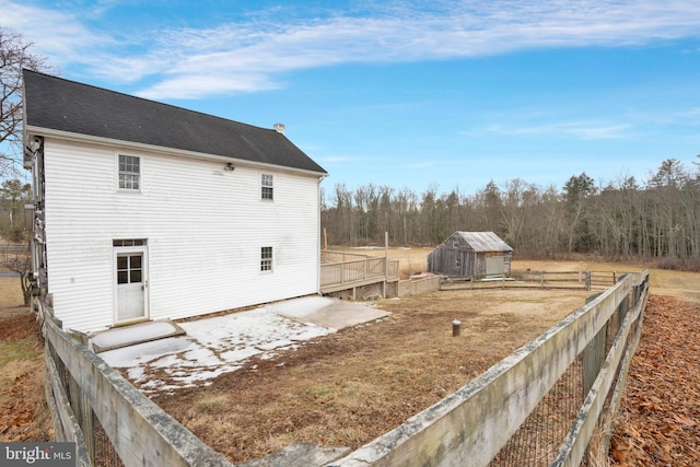 view of side of home with a deck and fence