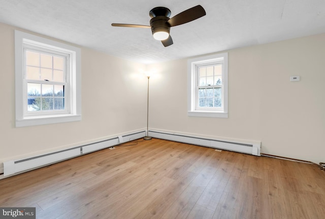 unfurnished room with ceiling fan, light wood-style flooring, and baseboard heating