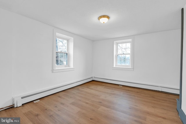 empty room with a healthy amount of sunlight and light wood finished floors