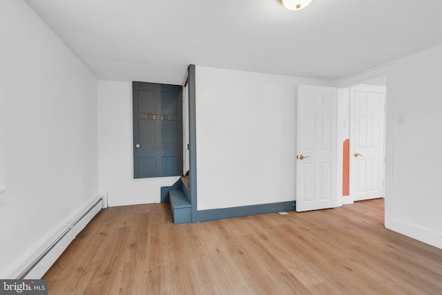 unfurnished room with light wood-type flooring, baseboards, and baseboard heating