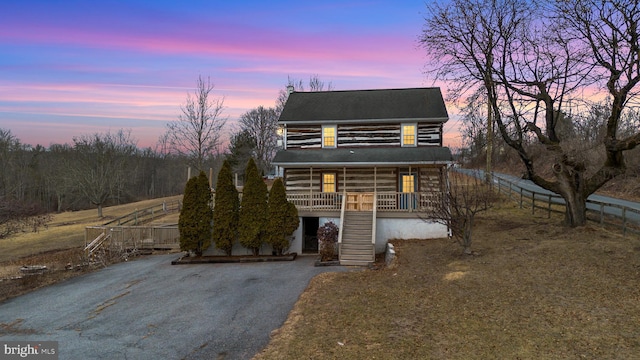 view of front facade with driveway, stairway, and a porch