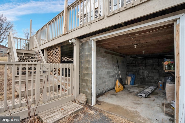 exterior space with concrete block siding, stairway, and a wooden deck