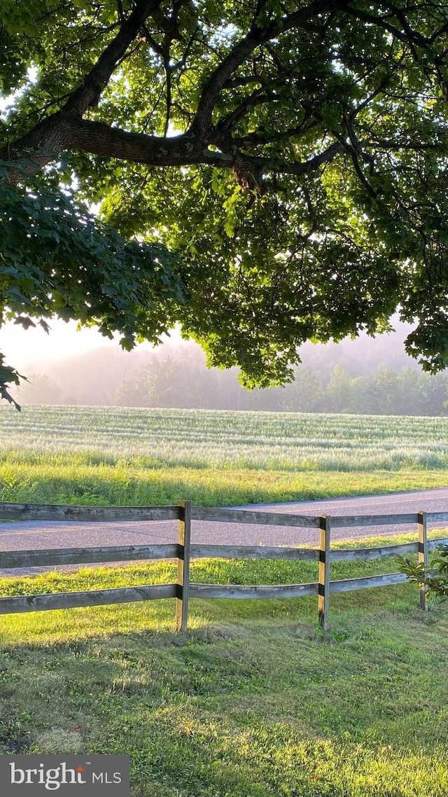 view of yard with a rural view and fence