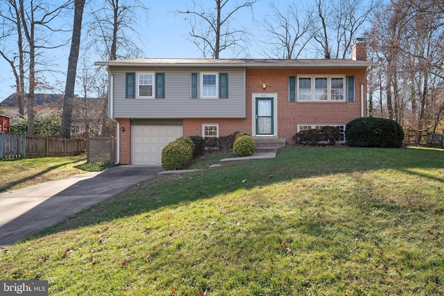 split foyer home featuring brick siding, a chimney, entry steps, fence, and driveway