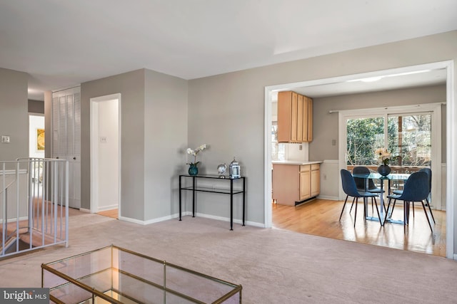 living room featuring light colored carpet and baseboards