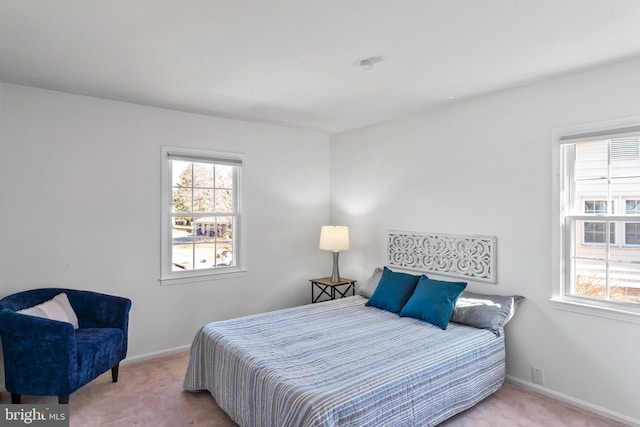 bedroom featuring carpet, multiple windows, and baseboards