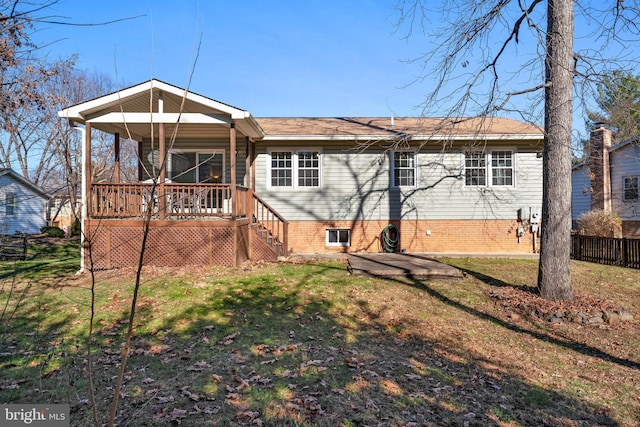 back of property featuring fence, a porch, and a yard