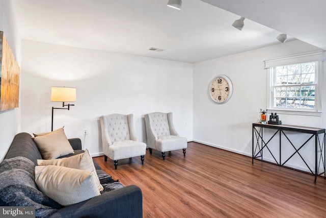 sitting room featuring baseboards, visible vents, and wood finished floors