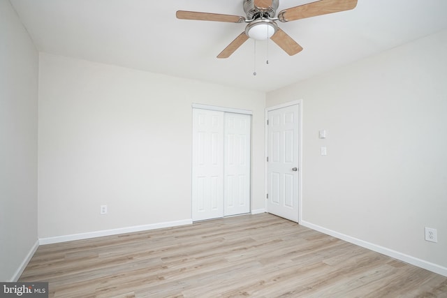 unfurnished bedroom with a closet, ceiling fan, baseboards, and wood finished floors