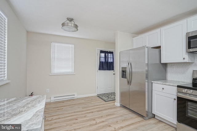 kitchen with light wood finished floors, white cabinetry, appliances with stainless steel finishes, and baseboard heating