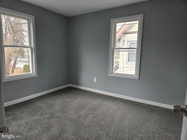 carpeted empty room featuring baseboards