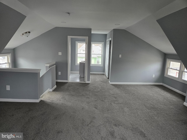 additional living space with vaulted ceiling, carpet floors, and baseboards