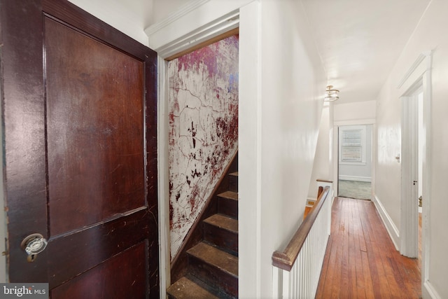 stairway featuring hardwood / wood-style floors and baseboards