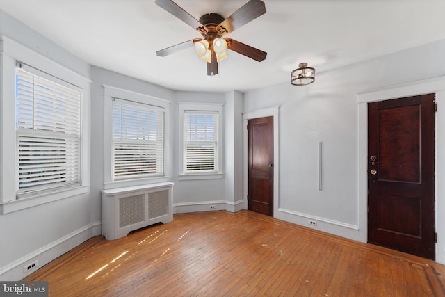 unfurnished bedroom with radiator, baseboards, and hardwood / wood-style floors