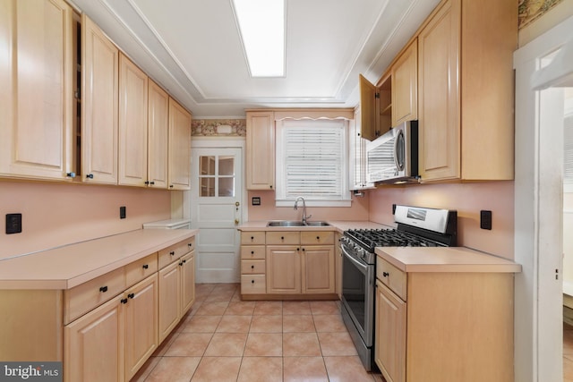 kitchen featuring light tile patterned floors, a sink, light brown cabinetry, light countertops, and appliances with stainless steel finishes