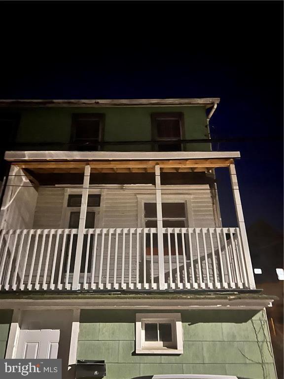 property exterior at twilight with a balcony