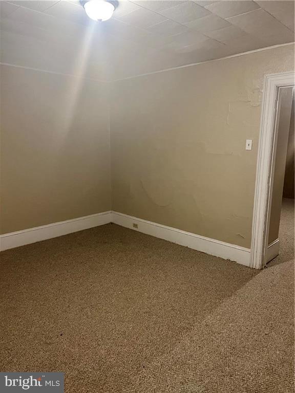 unfurnished room with carpet flooring and baseboards