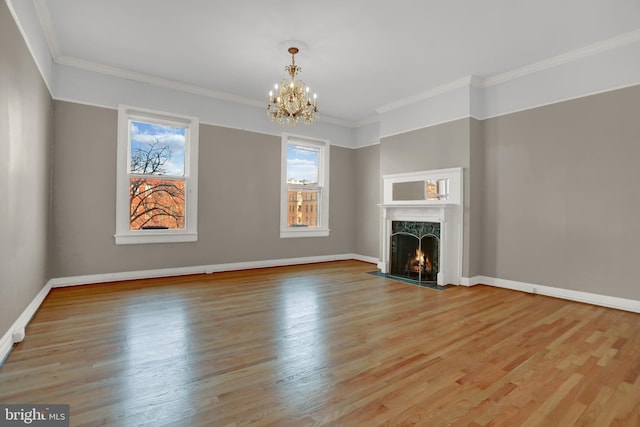 unfurnished living room featuring a chandelier, a premium fireplace, wood finished floors, and baseboards