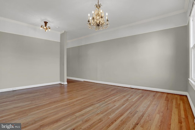 unfurnished room featuring light wood-type flooring, a notable chandelier, crown molding, and baseboards