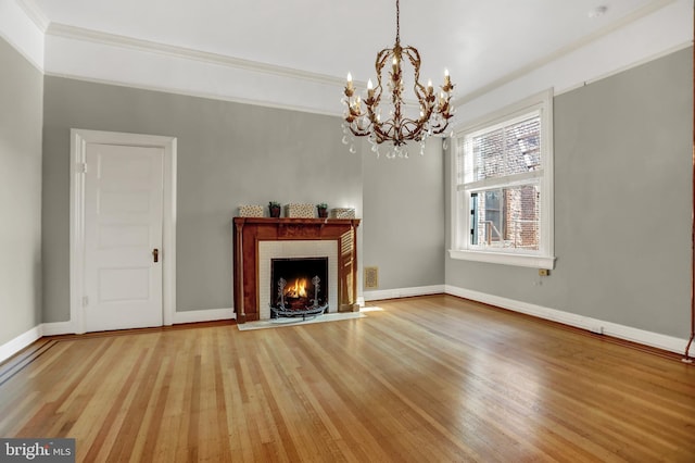 unfurnished living room featuring ornamental molding, a fireplace, light wood-style flooring, and baseboards