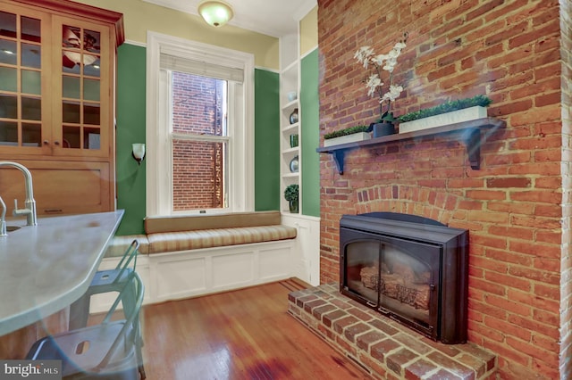 sitting room with brick wall and light wood-style floors