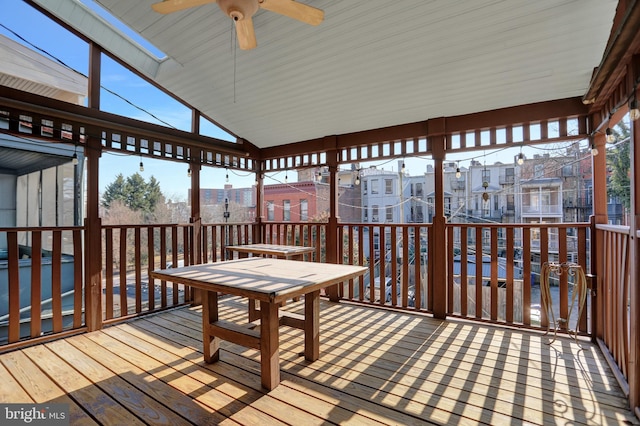 wooden terrace with outdoor dining space and a ceiling fan