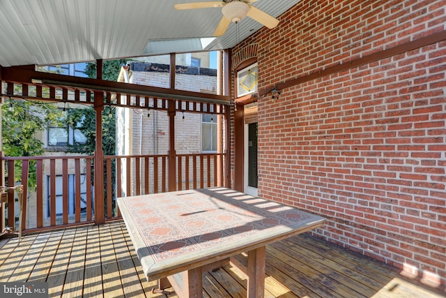 wooden terrace featuring outdoor dining space and ceiling fan