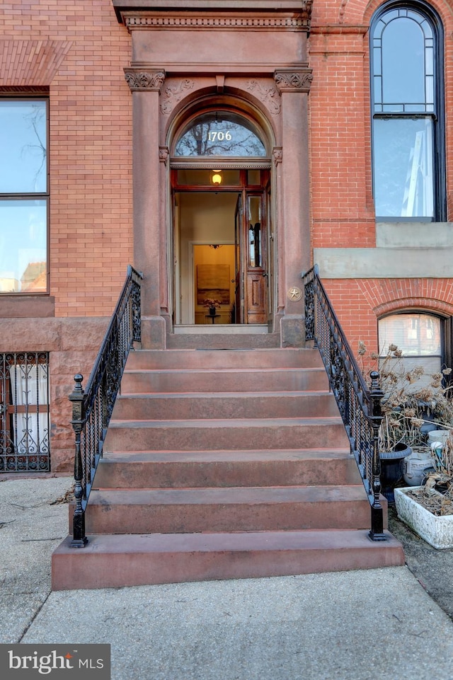 entrance to property featuring brick siding