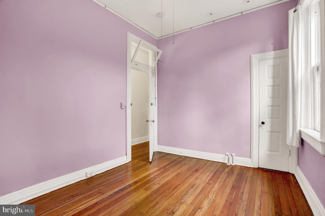 spare room featuring baseboards and hardwood / wood-style floors