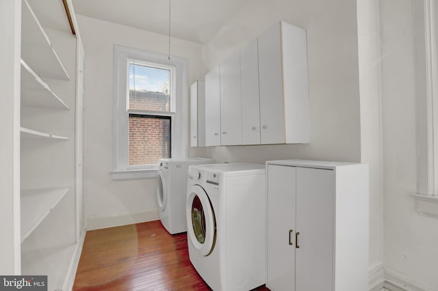 laundry room with baseboards, wood-type flooring, cabinet space, and washer and dryer