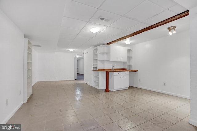 interior space featuring arched walkways, built in shelves, visible vents, and baseboards