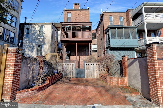 back of property featuring brick siding and fence