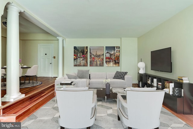 living area with light wood-style floors and decorative columns