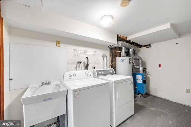 clothes washing area featuring washer and dryer, laundry area, water heater, and a sink