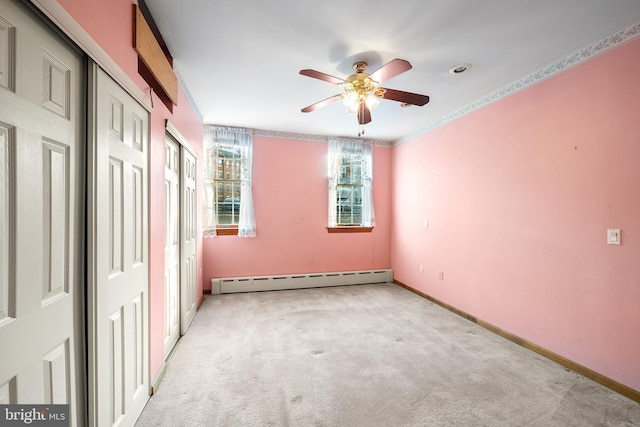 unfurnished bedroom with baseboards, a ceiling fan, light colored carpet, a baseboard heating unit, and multiple closets