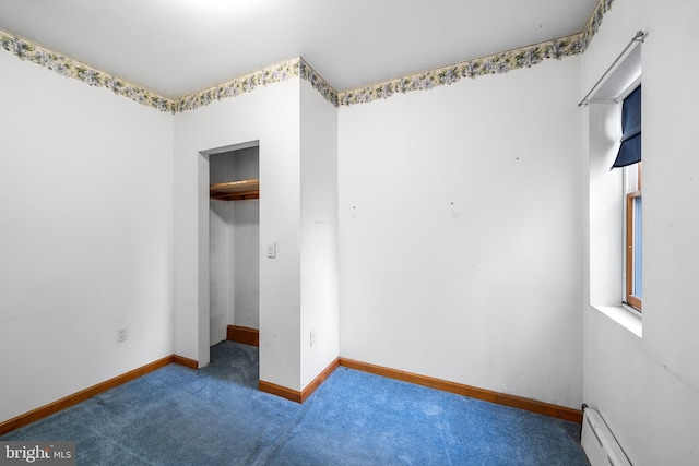 unfurnished bedroom featuring baseboards, a spacious closet, baseboard heating, carpet floors, and a closet