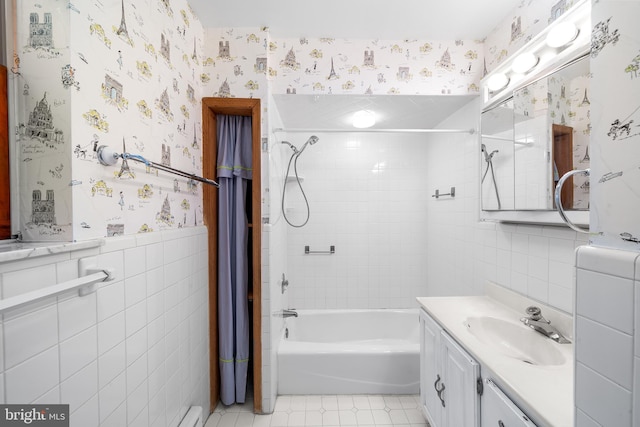 full bath featuring shower / tub combination, vanity, tile walls, wainscoting, and wallpapered walls