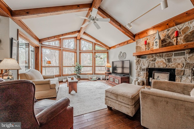 living area with lofted ceiling with beams, hardwood / wood-style floors, a fireplace, and a ceiling fan