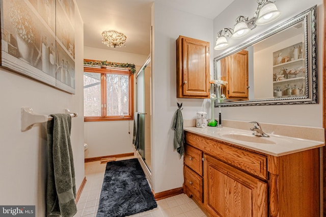 full bath with toilet, a stall shower, baseboards, and vanity