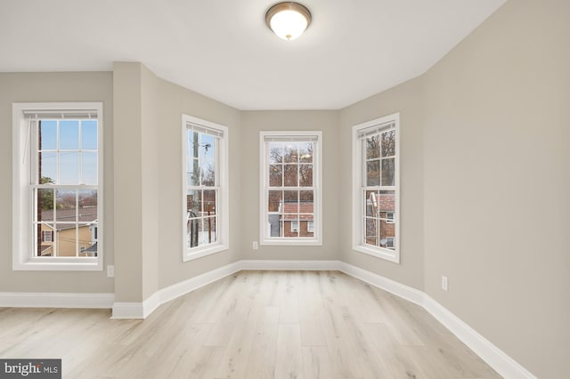 unfurnished dining area with baseboards and light wood finished floors